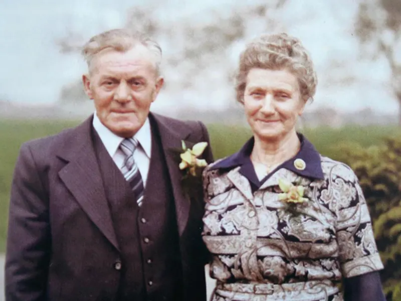 Op de foto ziet u Hans en Griet(je) Stokkink uit Oene. Tijdens de Tweede Wereldoorlog waren bij hen een Duitse deserteur en een Nederlandse verzetsman tegelijk ondergedoken. Dit tafereel wordt tijdens de fietstocht bij de familie Stokkink thuis nagespeeld.